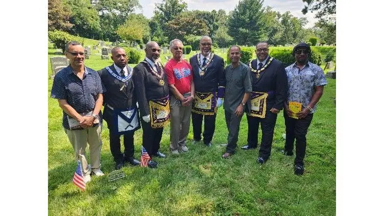 Dr. Robert Baskerville, founder and Executive Director of RISEUP, stands with Raymond Dugue of the UNIA and Dr. William Seraile, biographer of John Edward Bruce, alongside key supporters of the JEB Headstone Initiative.